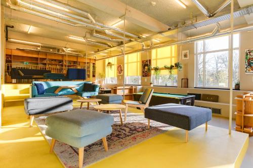 a living room with furniture and a pool table at ClinkNOORD Hostel in Amsterdam