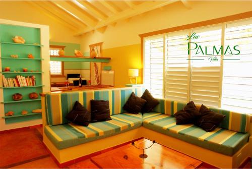 a living room with a couch in front of a window at Villa Las Palmas in Las Galeras