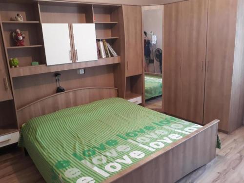 a bedroom with a bed with a green comforter at Apartments House Marija in Vrbanj