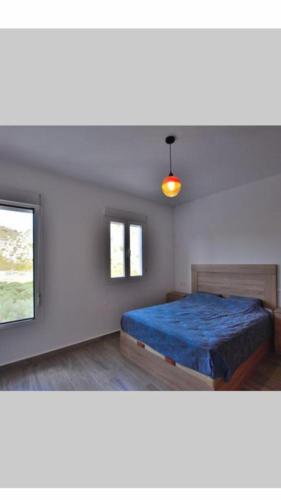 Un dormitorio con una cama azul y una ventana en casa el olivo en Montejaque