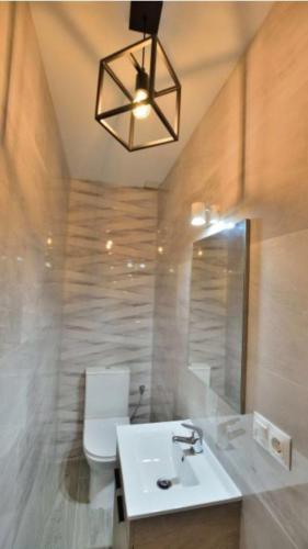 łazienka z umywalką, toaletą i lampką w obiekcie casa el olivo w mieście Montejaque