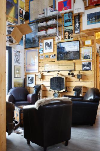 a living room with leather furniture and a wall with pictures at Camping Les Bois Flottés in Salin-de-Giraud