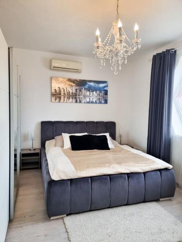 sypialnia z dużym łóżkiem i żyrandolem w obiekcie Spacious apartment near hockey and football arena w mieście Trnávka