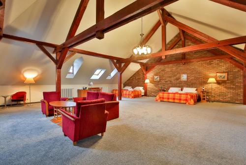 a large room with red chairs and a bed in a building at LH Hotel Dvořák Tábor Congress & Wellness in Tábor