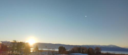a sunset over the mountains and a body of water at Marko Apartments in Struga
