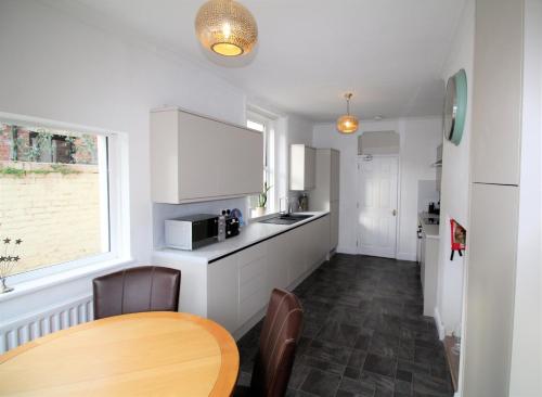 a kitchen with a wooden table and a dining room at Newcastle - Heaton - Great Customer Feedback - 5 Large Bedrooms - Period Property - Refurbished Throughout in Newcastle upon Tyne