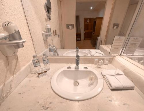 ein Bad mit einem Waschbecken und einem Spiegel in der Unterkunft HOTEL LAGOS INN in Lagos de Moreno