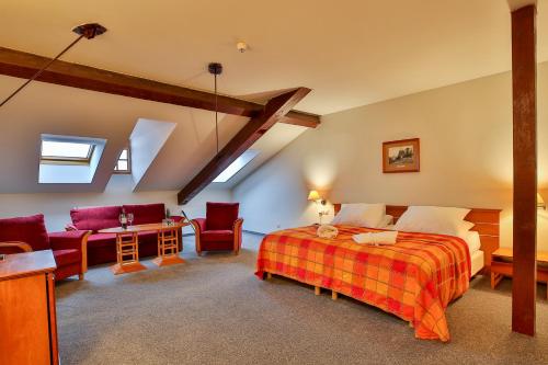 a bedroom with a bed and a table and chairs at LH Hotel Dvořák Tábor Congress & Wellness in Tábor