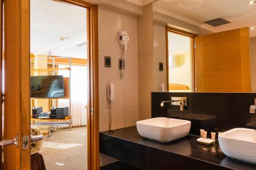 a bathroom with two sinks and a phone at Hotel Restaurante Ankara in Viña del Mar
