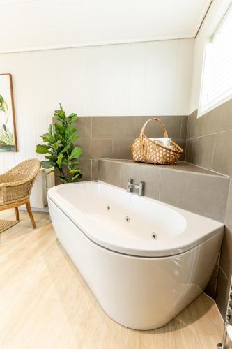 a white tub in a bathroom with a basket on the wall at Ribblesdale Park in Gisburn