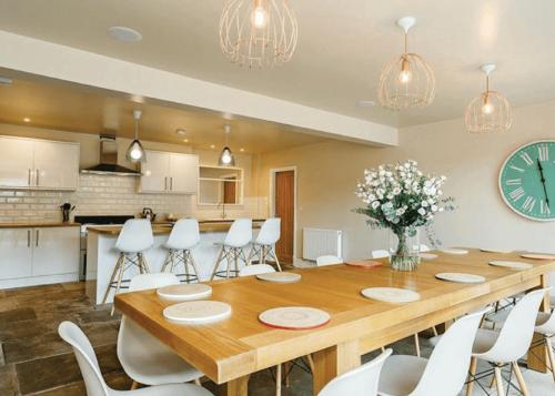a dining room with a large wooden table and white chairs at Ribblesdale Park in Gisburn