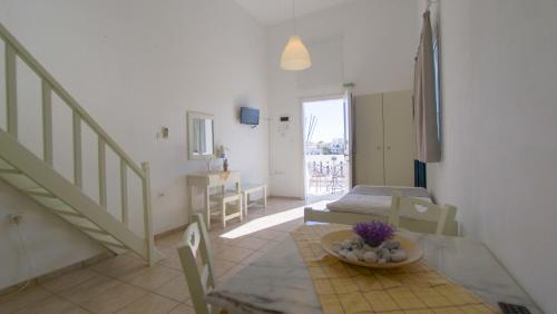 a living room with a dining table and a staircase at Ageri Studios in Astypalaia Town