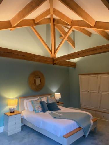 a bedroom with a large bed with wooden ceilings at Ribblesdale Park in Gisburn