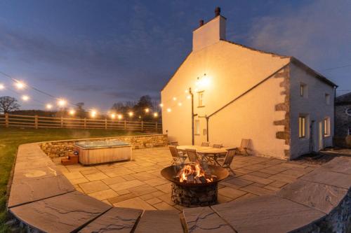 a patio with a fire pit in front of a church at Ribblesdale Park in Gisburn