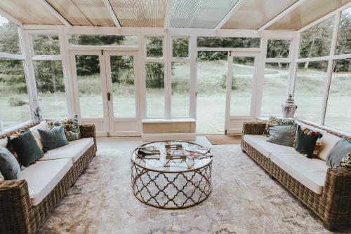 a screened in porch with couches and a coffee table at Ribblesdale Park in Gisburn