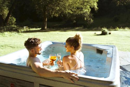 a man and woman in a hot tub with glasses of wine at Ribblesdale Park in Gisburn