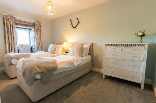 a bedroom with two twin beds and a dresser at Ribblesdale Park in Gisburn