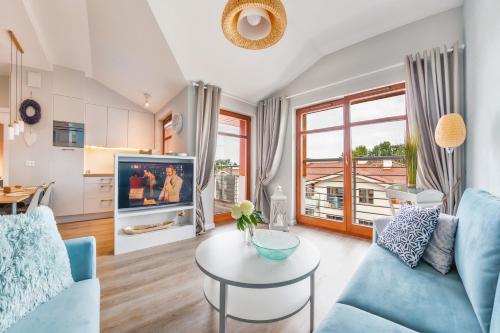 a living room with a blue couch and a table at Apartamenty Sun & Snow Neptun Park in Gdańsk