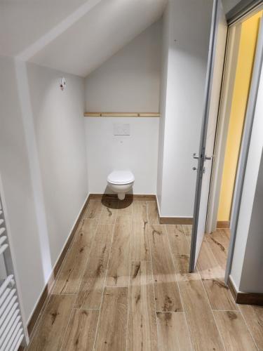 a bathroom with a toilet in the corner of a room at Chambres Jura Sud in Charchilla