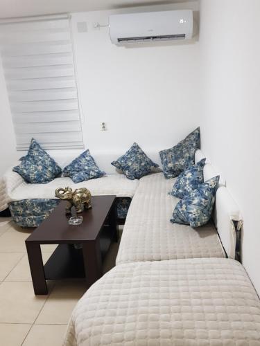 um quarto com 2 camas com almofadas azuis e uma mesa em Apartmani Strahinic em Leskovac