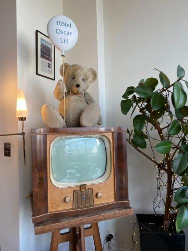 a teddy bear sitting on top of a tv at Oscar Hôtel Le Havre Centre in Le Havre