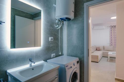Un baño con lavabo y lavadora. en J&M Luxury Apartments Saranda 2, en Sarandë