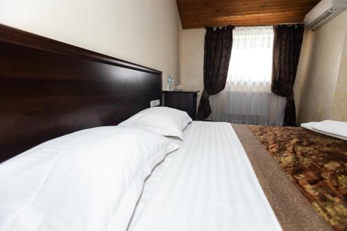 a bedroom with a large bed with white sheets at Готель Скіфія in Lviv