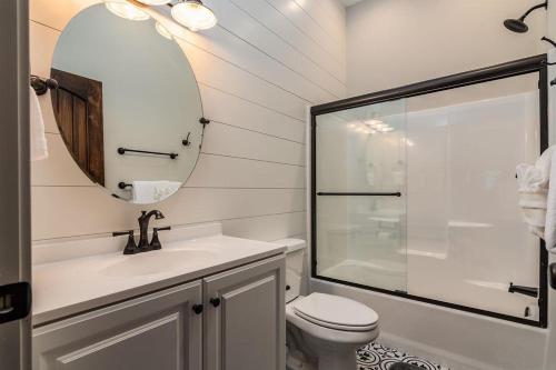 a bathroom with a toilet and a sink and a mirror at Cedarwood Farmstead in Ridgedale