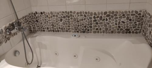 eine weiße Badewanne mit Dusche im Bad in der Unterkunft Chambre d'hôtes Les terrasses de Saint Clair in Sète