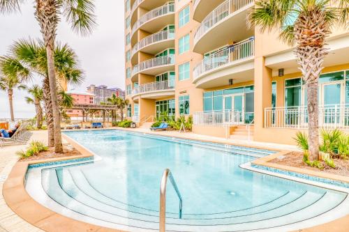- une piscine bordée de palmiers en face d'un bâtiment dans l'établissement Aqua 1604, à Panama City Beach