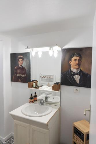 - une salle de bains avec lavabo et portrait d'un homme dans l'établissement Le Château Taison au coeur du centre ville, à Metz