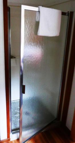 a glass door in a room with a towel at Slide Mountain Forest House in Oliverea
