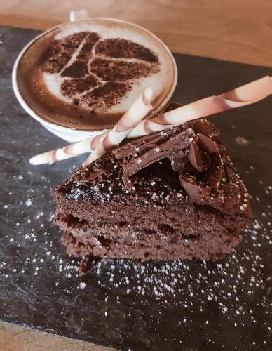 un gâteau au chocolat et une tasse de café dans l'établissement The Okeover Arms, à Ashbourne