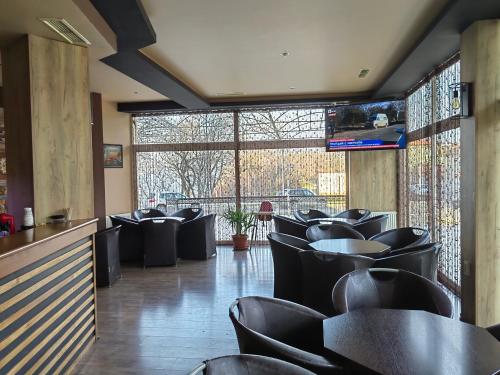 a dining room with black chairs and windows at Family Hotel Diana in Tsarevo