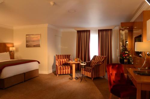 a hotel room with a bed and a desk and chairs at Clanree Hotel & Leisure Centre in Letterkenny