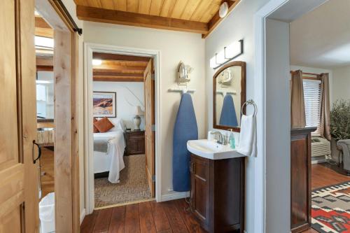 a bathroom with a sink and a bedroom at Stone Lizard Lodge in Blanding