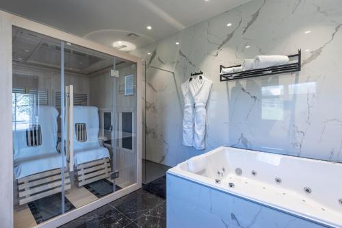 a bathroom with a tub and a glass shower at Domaine du Grand Bec in Villerville