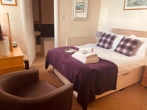 a hotel room with a bed and a chair at The Crossroads Inn in Halifax