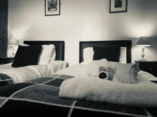 a bedroom with two beds with a teddy bear on it at The Crossroads Inn in Halifax