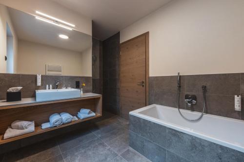 馬萊斯韋諾斯塔的住宿－Maraiashof，带浴缸和盥洗盆的浴室