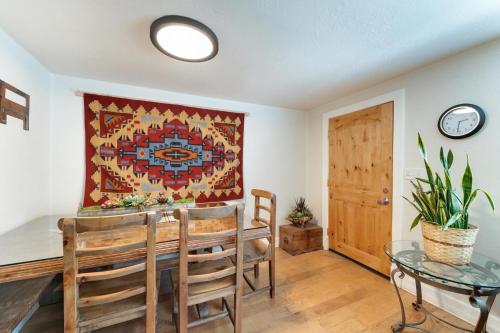 a dining room with a table and a rug on the wall at Stone Lizard Lodge in Blanding