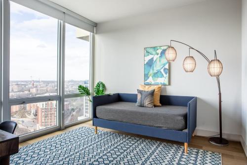 a bedroom with a blue bed and large windows at Mint House Dallas - Victory Park in Dallas
