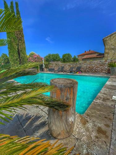 - une piscine avec un banc en bois à côté dans l'établissement LA PARENTHESE, à Manduel