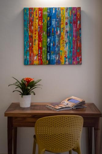 a table with a plant and a painting on the wall at Palazzo San Lazzaro - Jacuzzi Rooms & Suites Lecce Selection in Lecce