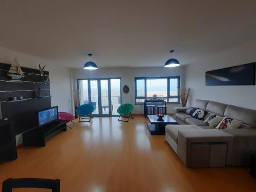 a living room with a couch and a tv at DUPLEX in Nazaré