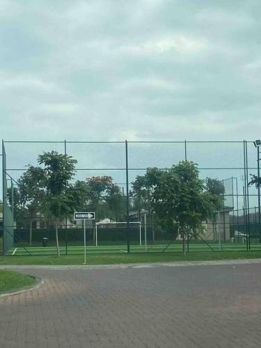 una valla frente a un campo con árboles en Departamento en La joya full, en Guayaquil