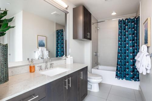 a bathroom with a sink and a toilet and a mirror at Locale Victory Park - Dallas in Dallas