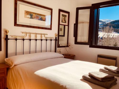 a bedroom with a bed with a window and towels at P05 1 dormitori falco in Barruera