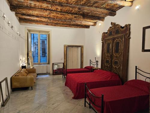 a room with three beds with red sheets at The Spanish Palace Rooms, Suites Apartments & Terraces in Naples
