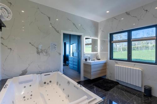 a large bathroom with a tub and a sink at Domaine du Grand Bec in Villerville